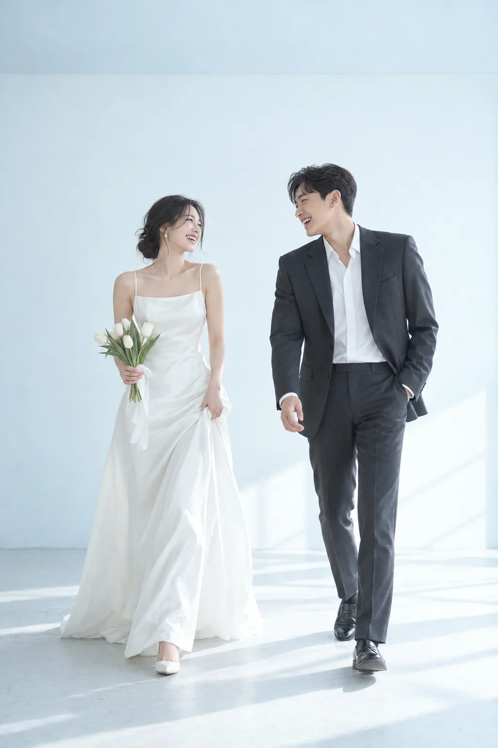 Bride and groom walking through a bright studio